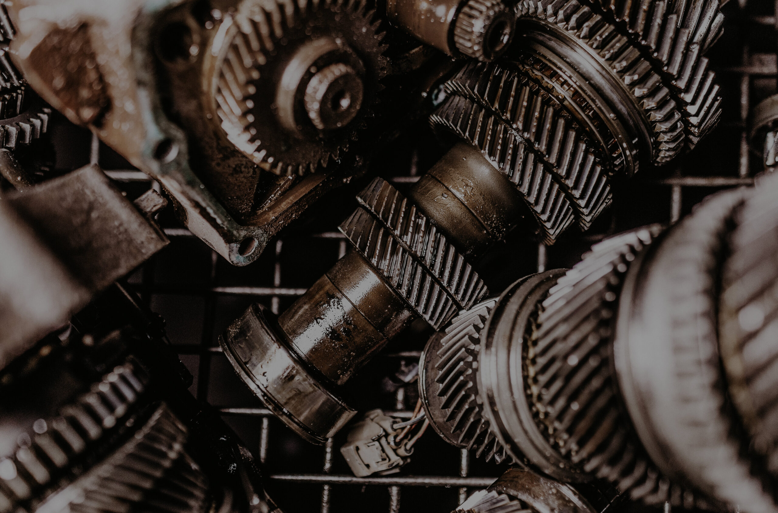A closeup shot of dirty metal gears on a grid under light