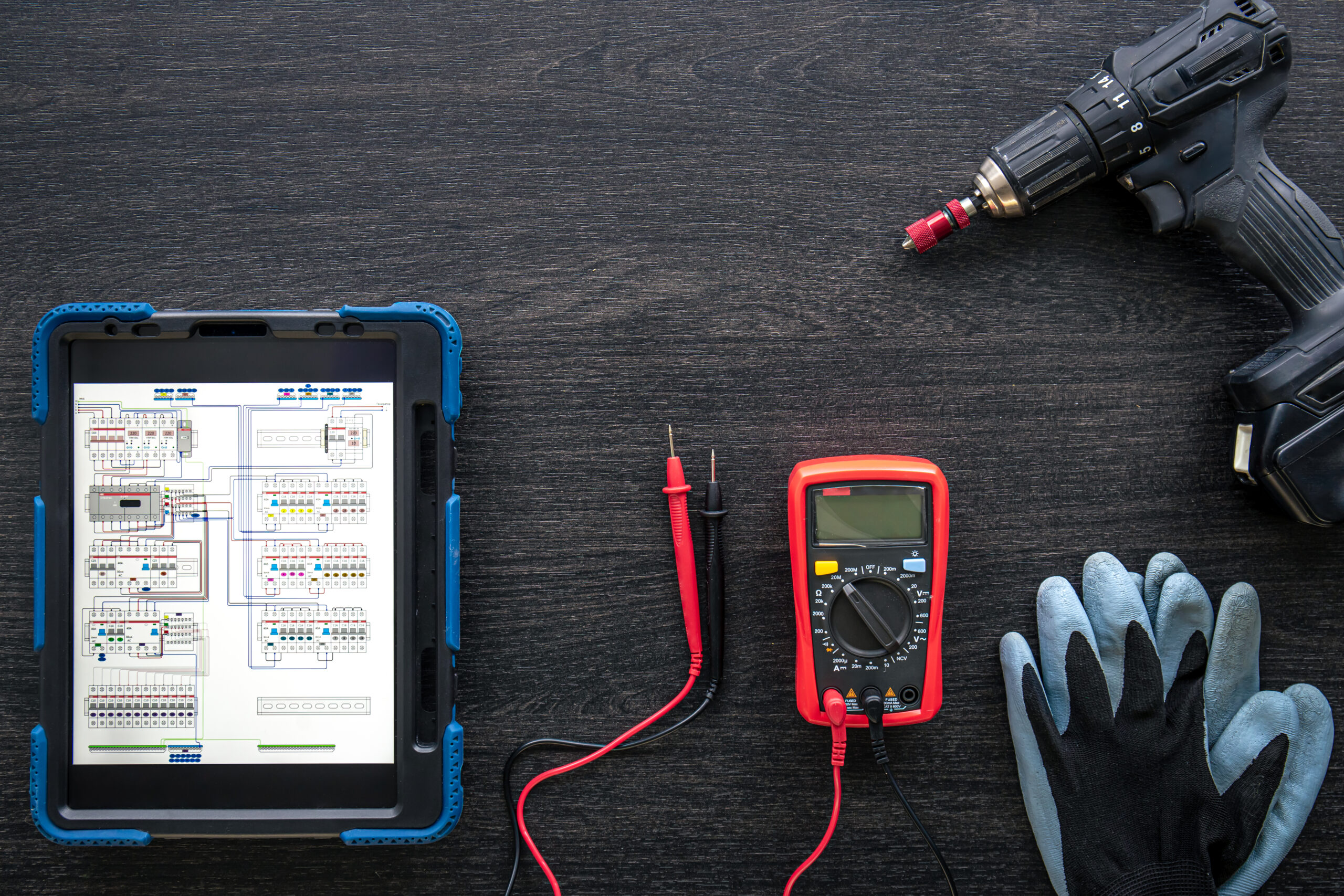 Composition with digital tablet and electrician work items, top view.